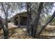 View of the home's exterior and covered patio framed by large shade trees at 1742 E Chaparral Dr, Casa Grande, AZ 85122