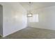Bright, carpeted dining room with an elegant hanging light fixture and vaulted ceilings at 1742 E Chaparral Dr, Casa Grande, AZ 85122