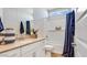 Modern bathroom featuring a shower-tub combo, tan quartz countertop, and white shaker cabinets at 17479 W Victory St, Goodyear, AZ 85338