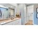 Bathroom with a double sink vanity, quartz counters, walk-in shower, and modern fixtures at 17479 W Victory St, Goodyear, AZ 85338