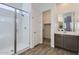 A bathroom features a tiled floor, glass shower, vanity, and a walk-in closet at 17545 W Victory St, Goodyear, AZ 85338