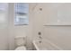 Bathroom features tile tub/shower, white subway tile and window with blinds at 17545 W Victory St, Goodyear, AZ 85338