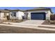 Charming single-story home featuring a blue garage door, desert landscaping, and a well-maintained front yard at 17545 W Victory St, Goodyear, AZ 85338