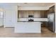 Modern kitchen with stainless steel appliances, a spacious island, and ample cabinetry for storage and functionality at 17545 W Victory St, Goodyear, AZ 85338
