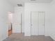 A bedroom with neutral carpet and a door leading to the en suite bathroom at 17806 W Vogel Ave, Waddell, AZ 85355