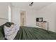 Bedroom with dresser and TV, green bedding, carpet flooring, and window for natural light at 19585 W Washington St, Buckeye, AZ 85326