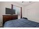 A bedroom featuring a television on a dresser, a window, and closet with blue bedding at 19585 W Washington St, Buckeye, AZ 85326
