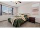 Bedroom with window, neutral bedding, carpet, side table, and dresser at 19585 W Washington St, Buckeye, AZ 85326