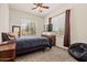 Bedroom with neutral carpeting, a ceiling fan and closet with TV on dresser at 19585 W Washington St, Buckeye, AZ 85326