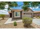 Charming home featuring a two-car garage, a driveway, desert landscaping, and a stone accent at 19585 W Washington St, Buckeye, AZ 85326
