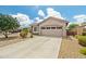Charming home featuring a two-car garage, a driveway, and desert landscaping, showcasing curb appeal at 19585 W Washington St, Buckeye, AZ 85326