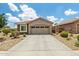 Charming home featuring a two-car garage, a driveway, and desert landscaping, with a stone accent at 19585 W Washington St, Buckeye, AZ 85326