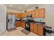 Well-lit kitchen boasts wooden cabinets, black countertops, modern stainless steel appliances, and ample storage space at 19585 W Washington St, Buckeye, AZ 85326