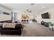 Spacious living room featuring a comfortable black leather sofa and an open layout to the kitchen and dining area at 19585 W Washington St, Buckeye, AZ 85326
