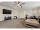 Spacious living room featuring a large TV, neutral paint, carpet, and furniture at 19585 W Washington St, Buckeye, AZ 85326