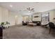 Spacious living room with modern ceiling fan, neutral paint, carpet, and lots of natural light at 19585 W Washington St, Buckeye, AZ 85326