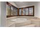 Bright bathroom featuring a jacuzzi tub with tile surround and shuttered windows at 2149 E Hermosa Vista Dr, Mesa, AZ 85213