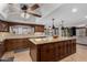 The spacious kitchen features a large island, custom wood cabinets, a ceiling fan, and tile flooring at 2149 E Hermosa Vista Dr, Mesa, AZ 85213