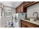 Well-lit laundry room with built-in cabinetry, granite counters, sink, and new washer and dryer at 2149 E Hermosa Vista Dr, Mesa, AZ 85213