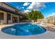 Sparkling pool with custom rock waterfall feature and adjacent covered patio at 2149 E Hermosa Vista Dr, Mesa, AZ 85213