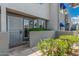 Inviting condo featuring a secure gate, a vibrant garden, and lovely blue awnings over the windows at 220 N 22Nd Pl # 1022, Mesa, AZ 85213