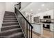 This home features stairs that lead up to a kitchen with stainless steel appliances, white cabinets, and light wood floors at 220 N 22Nd Pl # 1022, Mesa, AZ 85213