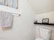 A modern bathroom with white walls, a shelf, a toilet, and a small window dressed with a lace curtain at 2301 E University Dr # 341, Mesa, AZ 85213