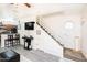 An open-concept living space with vinyl flooring, a staircase with white rails, and natural light from the octagonal window at 2301 E University Dr # 341, Mesa, AZ 85213