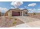 Beautiful single-story home showcasing a two-car garage and inviting landscaping, set against a bright, cloudy sky at 25332 N 133Rd Ave, Peoria, AZ 85383