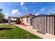 Landscaped backyard with a metal shed, covered patio, and gravel area at 2635 W Atlanta Ave, Phoenix, AZ 85041