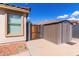Enclosed backyard area featuring a storage shed, wooden gate, and gravel accents, offering functionality and privacy at 2635 W Atlanta Ave, Phoenix, AZ 85041