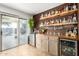 Wet bar boasts custom wood shelves, a mini fridge, and easy access to the backyard through sliding glass doors at 2635 W Atlanta Ave, Phoenix, AZ 85041