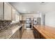 Kitchen features stainless steel appliances, a tiled backsplash, granite countertops, and an island with barstool seating at 2635 W Atlanta Ave, Phoenix, AZ 85041