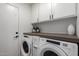 Bright laundry room features white cabinets and modern washer and dryer at 2635 W Atlanta Ave, Phoenix, AZ 85041