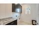 Well-appointed laundry room with stylish wallpaper, granite counters, and cabinetry for efficient laundry tasks at 26355 N 79Th Dr, Peoria, AZ 85383