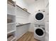 Well-organized laundry room with stackable washer/dryer and built-in shelving at 26355 N 79Th Dr, Peoria, AZ 85383