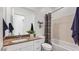 Bright bathroom featuring a quartz countertop vanity, decorative accents, and a shower-over-tub with a stylish plaid curtain at 26391 N 79Th Dr, Peoria, AZ 85383