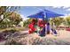 Bright and cheerful playground featuring a red slide, blue sunshade, and other play equipment, nestled in landscaped surroundings at 26391 N 79Th Dr, Peoria, AZ 85383