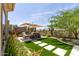 Lush backyard features synthetic grass, patio, seating area, and desert landscaping at 3045 W Feather Sound Dr, Phoenix, AZ 85086