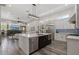 Bright kitchen with a large island featuring seating and stainless steel appliances open to a living area with fireplace at 3045 W Feather Sound Dr, Phoenix, AZ 85086
