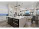Open-concept kitchen showcasing modern island with quartz countertop and seating, with stainless appliances and fireplace at 3045 W Feather Sound Dr, Phoenix, AZ 85086