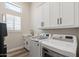 Laundry room with sink, storage, and modern appliances at 3045 W Feather Sound Dr, Phoenix, AZ 85086