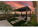 Covered outdoor dining area with beautiful sunset views featuring BBQ and desert landscaping at 3045 W Feather Sound Dr, Phoenix, AZ 85086