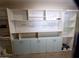 Garage boasts extensive storage solutions, including upper and lower cabinets, shelves, and a pegboard at 3216 E Campo Bello Dr, Phoenix, AZ 85032