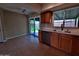 A well-lit kitchen featuring light countertops, wooden cabinets, and access to the backyard at 3216 E Campo Bello Dr, Phoenix, AZ 85032