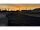 Scenic sunset view of a desert road lined with saguaro cacti, embodying serene desert living at 3502 S Kings Ranch Rd, Gold Canyon, AZ 85118
