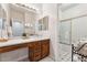 Bathroom with a wood vanity, large mirror, and a shower over tub with glass doors at 3750 E Palm St, Mesa, AZ 85215