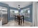 Bright dining area with modern table, tile floors, lots of natural light, and stainless steel refrigerator in kitchen at 4049 E Arbor Ave, Mesa, AZ 85206
