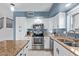 Cozy kitchen with granite countertops, stainless steel appliances, white cabinets, and lots of natural light from the window at 4049 E Arbor Ave, Mesa, AZ 85206