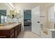 Bathroom featuring dual sinks, a soaking tub, and access to main bedroom at 4049 E Arbor Ave, Mesa, AZ 85206